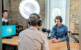 Men speaking onto microphone