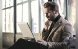 Man confusedly staring at his laptop screen