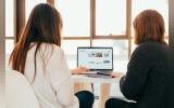 two ladies looking at a laptop screen